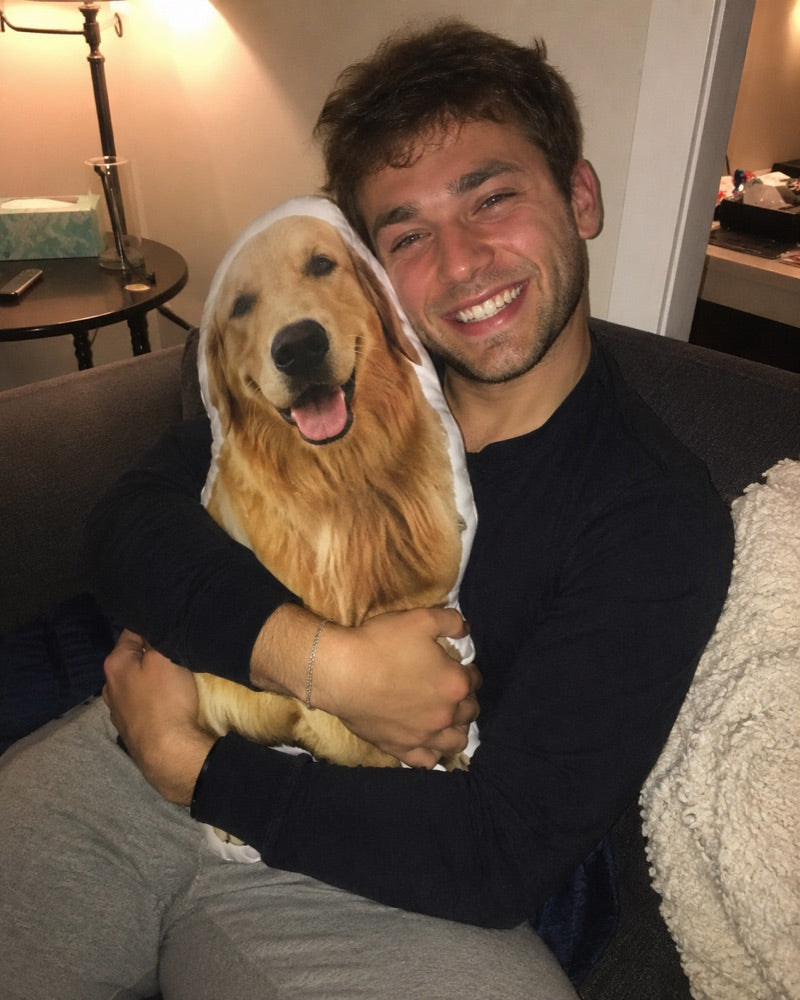 Man knuffelt het fotokussen van zijn golden retriever