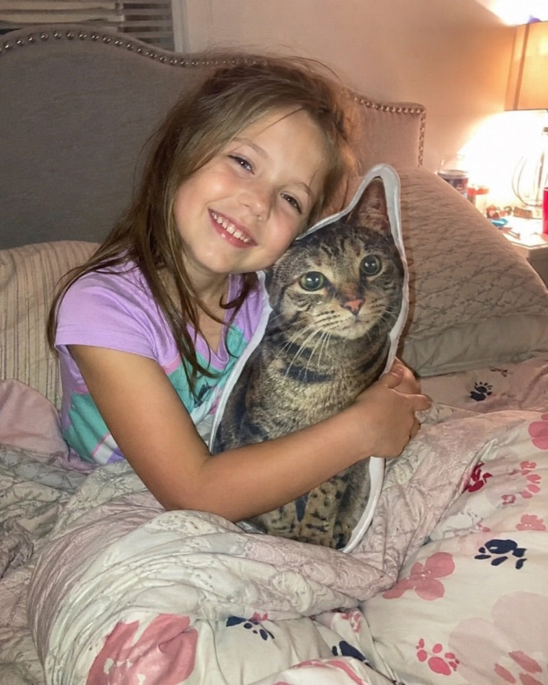 Meisje in bed met het fotokussen van haar kat