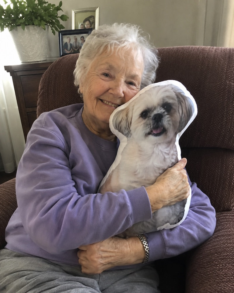 Oma knuffelt het fotokussen van haar hondje